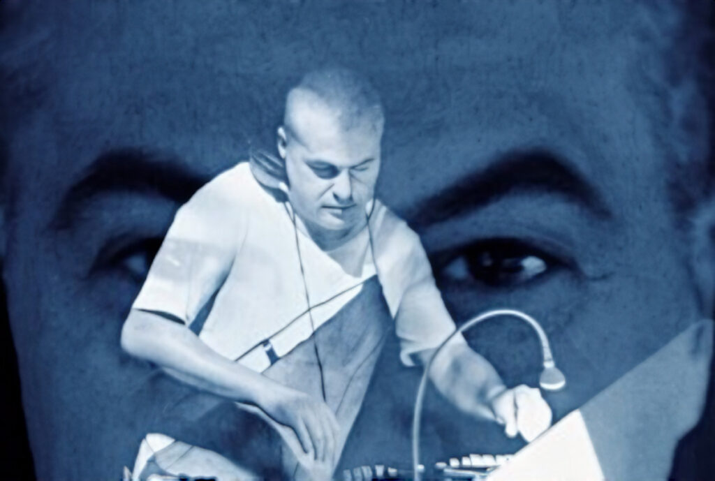 File name: marco-mei-performing-with-projected-portrait.jpg Alt text: Marco Mei performs at an event with a projected image behind him, representing his long-running work across House, Techno and underground electronic music.