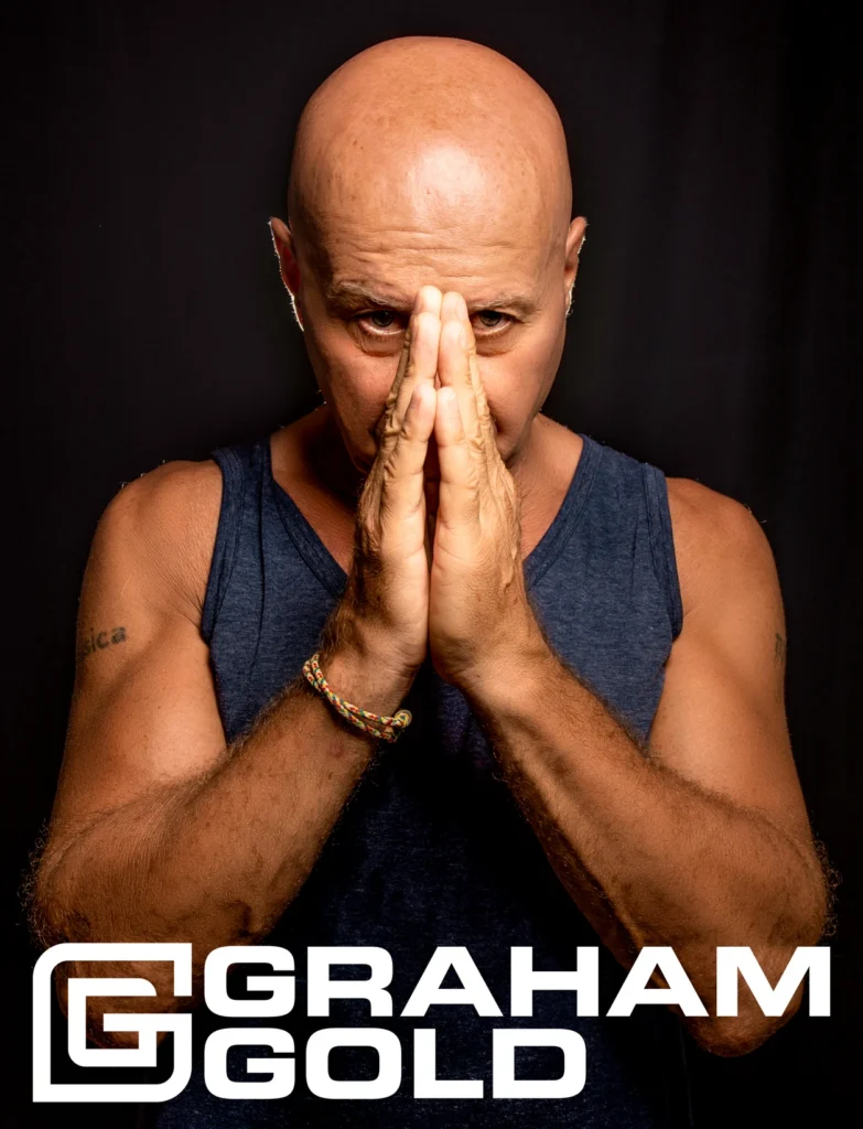 Promotional portrait of British DJ Graham Gold with hands together and logo text underneath, representing his long-running work across House, Trance and electronic music.