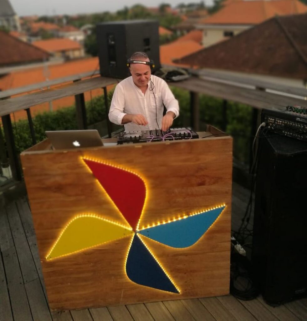 Marco Mei performs an outdoor DJ set on a rooftop terrace, representing his long-running work across House, Techno and underground electronic music.