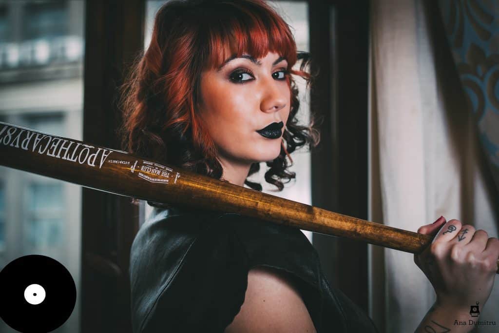Colour portrait of Romanian Techno DJ and producer Deysa holding a baseball bat over her shoulder, representing her underground Techno sound and striking visual style.