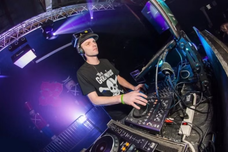 Jan Capozziello, Connecticut-based DJ and promoter, performing at the decks in a club setting.