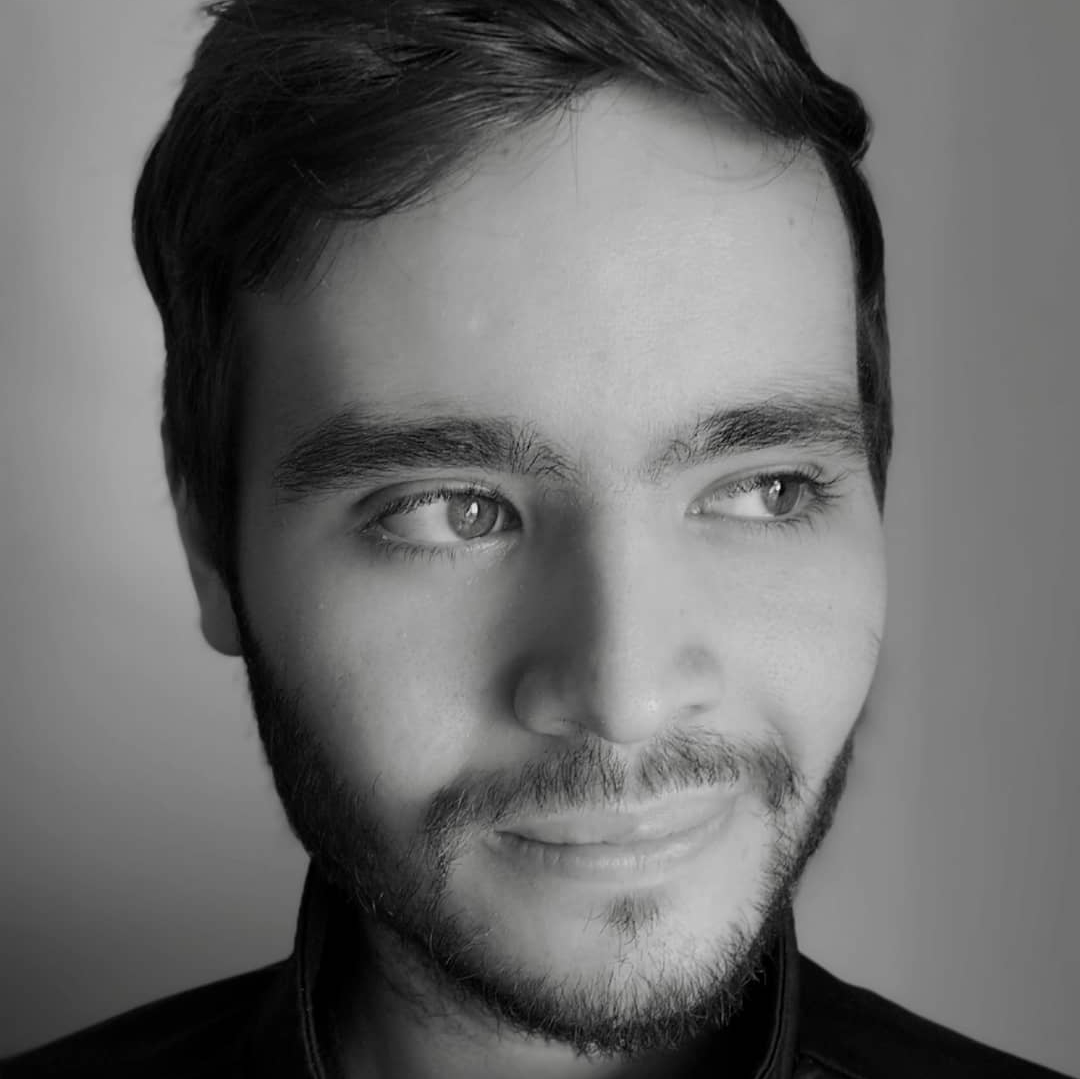 Argentinian DJ and producer Serge Canteros smiling wryly in head shot, black and white image.