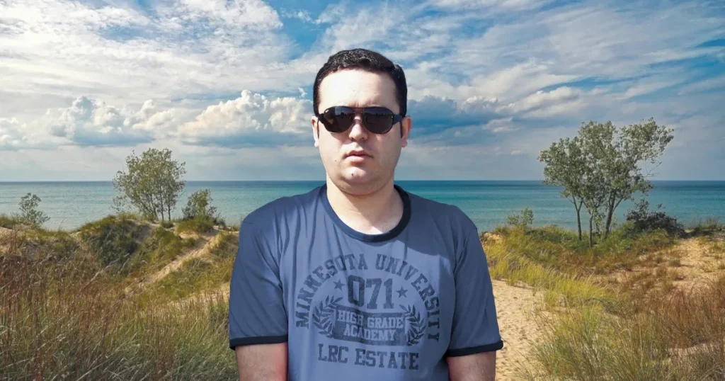 Portuguese DJ Joshua standing on a mangrove grassy beach in in Portugal, colour image.
