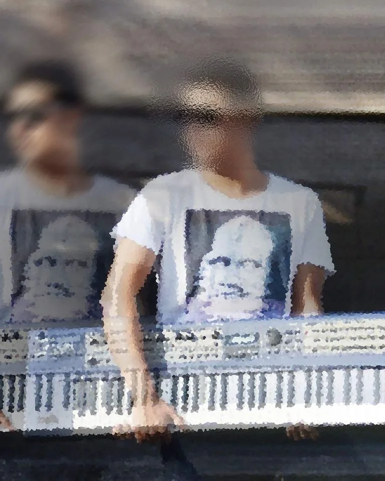 Mexican DJ and producer Muuk' holding an electric piano and syntheiser, colour image.