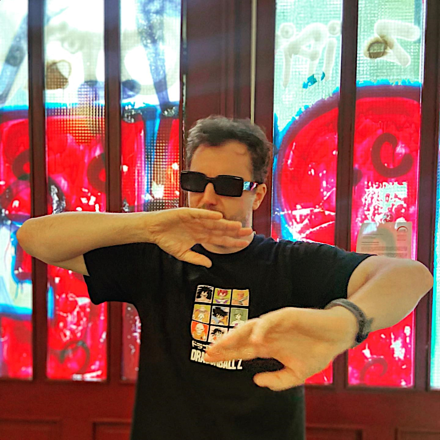 Italian DJ and producer Nico Cabeza standing with his hands in front of him wearing sunglasses, colour image.