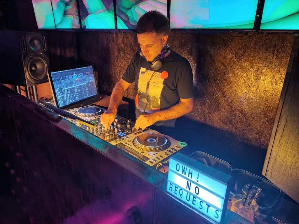 British DJ Dimensions performing at an event, colour image.