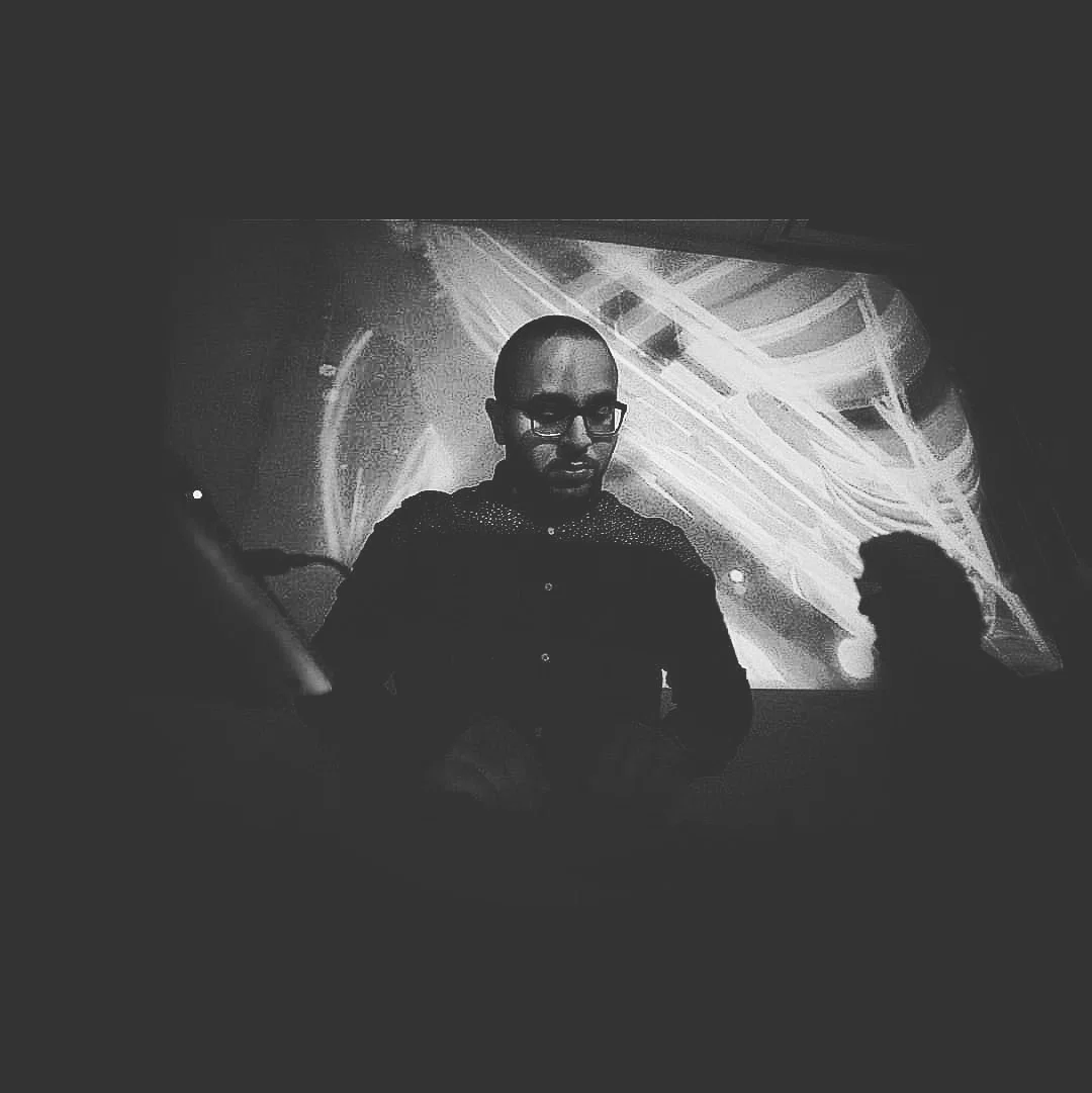 Montreal DJ and producer Jares performs in dark event lighting with abstract visuals behind him, representing his deep, progressive and orchestral electronic sound.