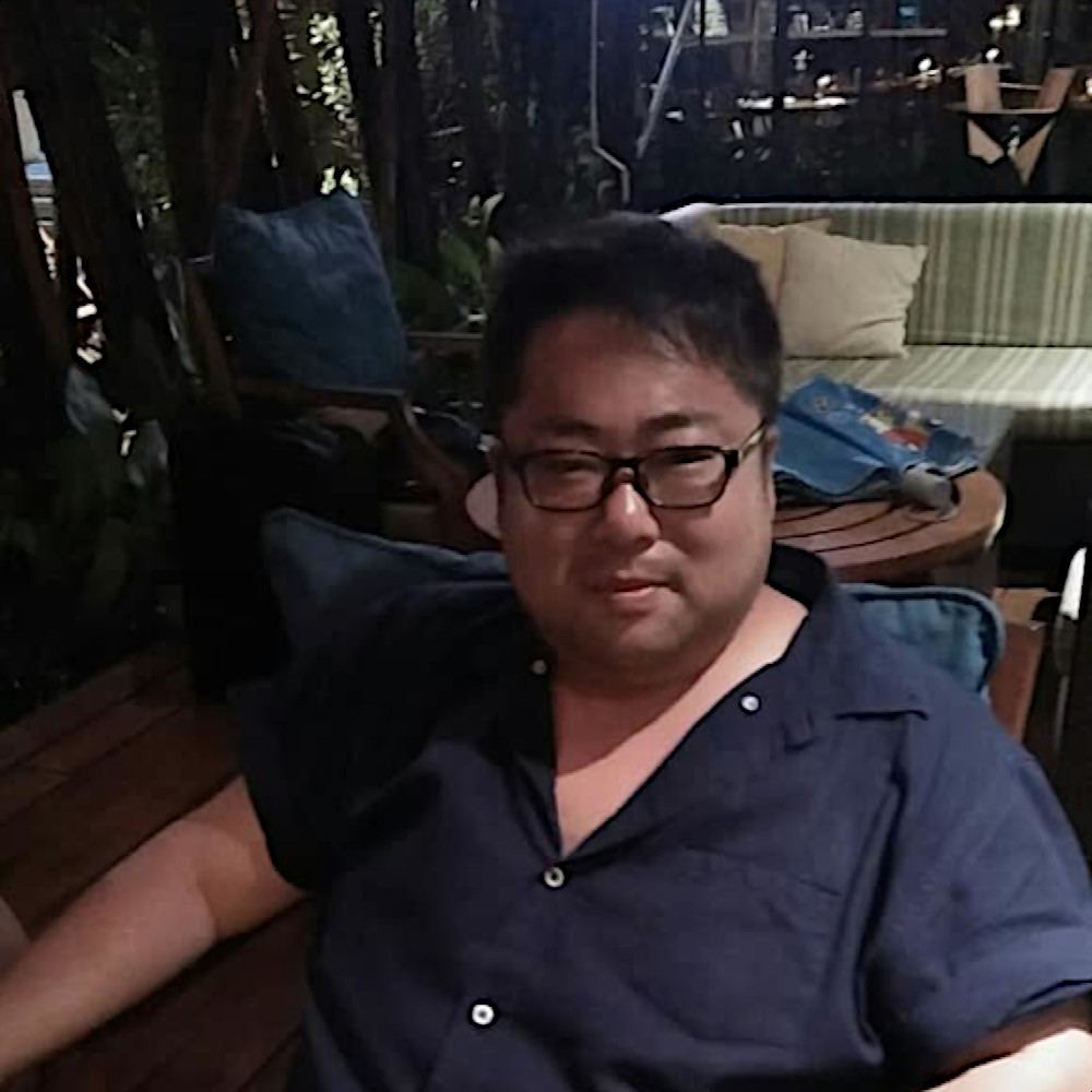 Japanese DJ Marcy sitting in a chair looking at cameraman, colour image.