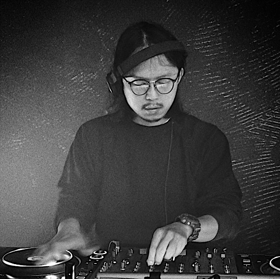 Taiwanese DJ and producer KJ Stone performing on Pioneer DJ equipment, black and white image.