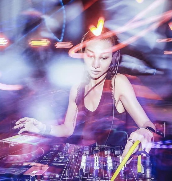 Chinese DJ and producer Jasmine Li performing at an event, colour image.