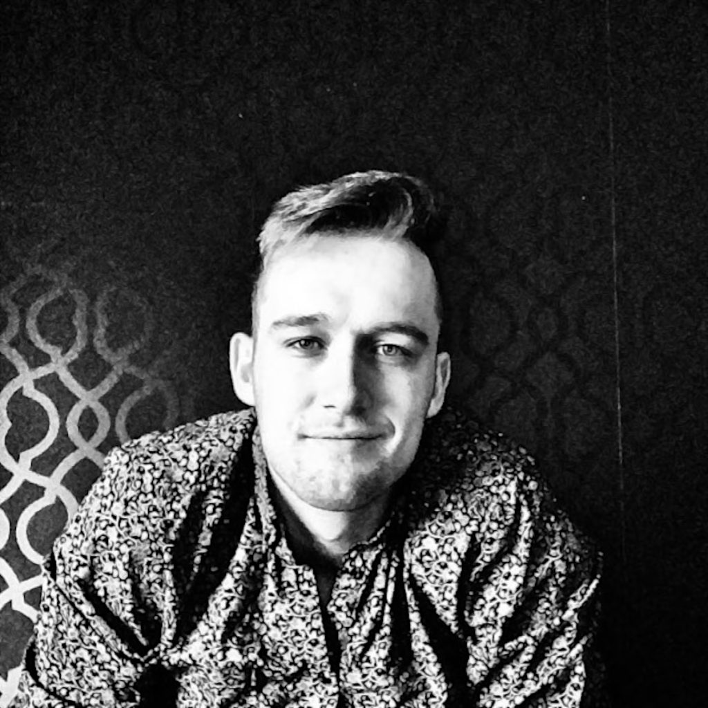 Canadian DJ and producer Andrew Welman looking at camera in upper body shot whilst smiling, black and white image.