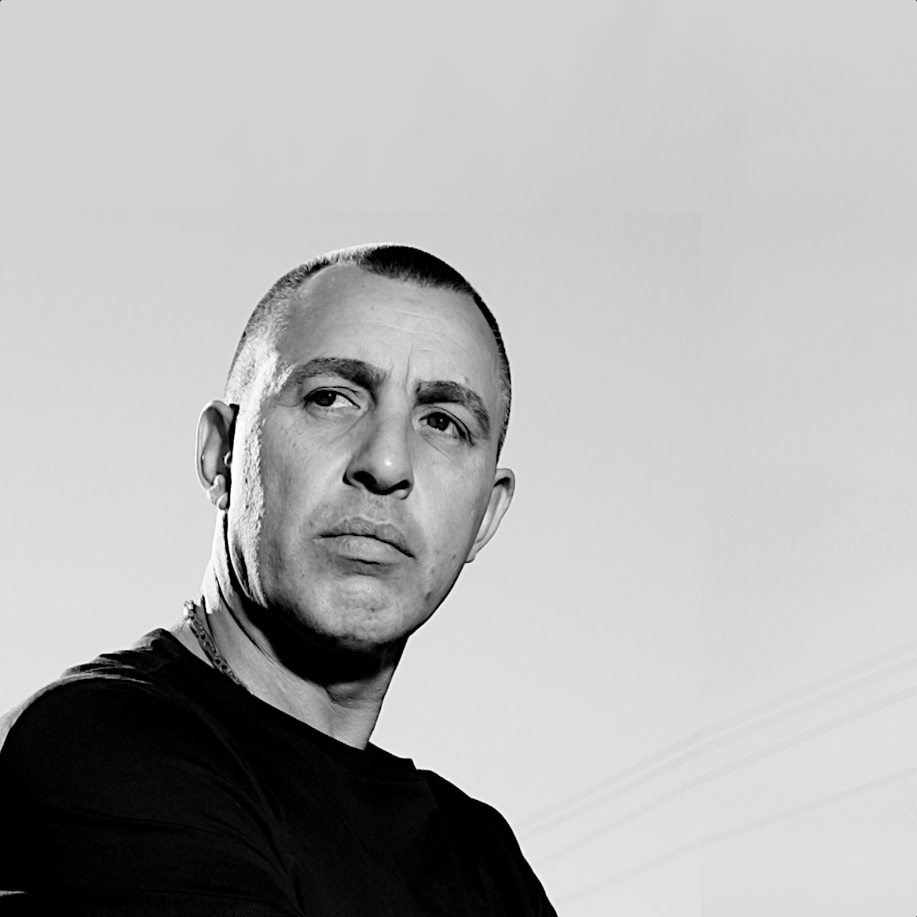 Armenian American DJ and producer Ruben Karapetyan looking at camera over his right shoulder, black and white image.