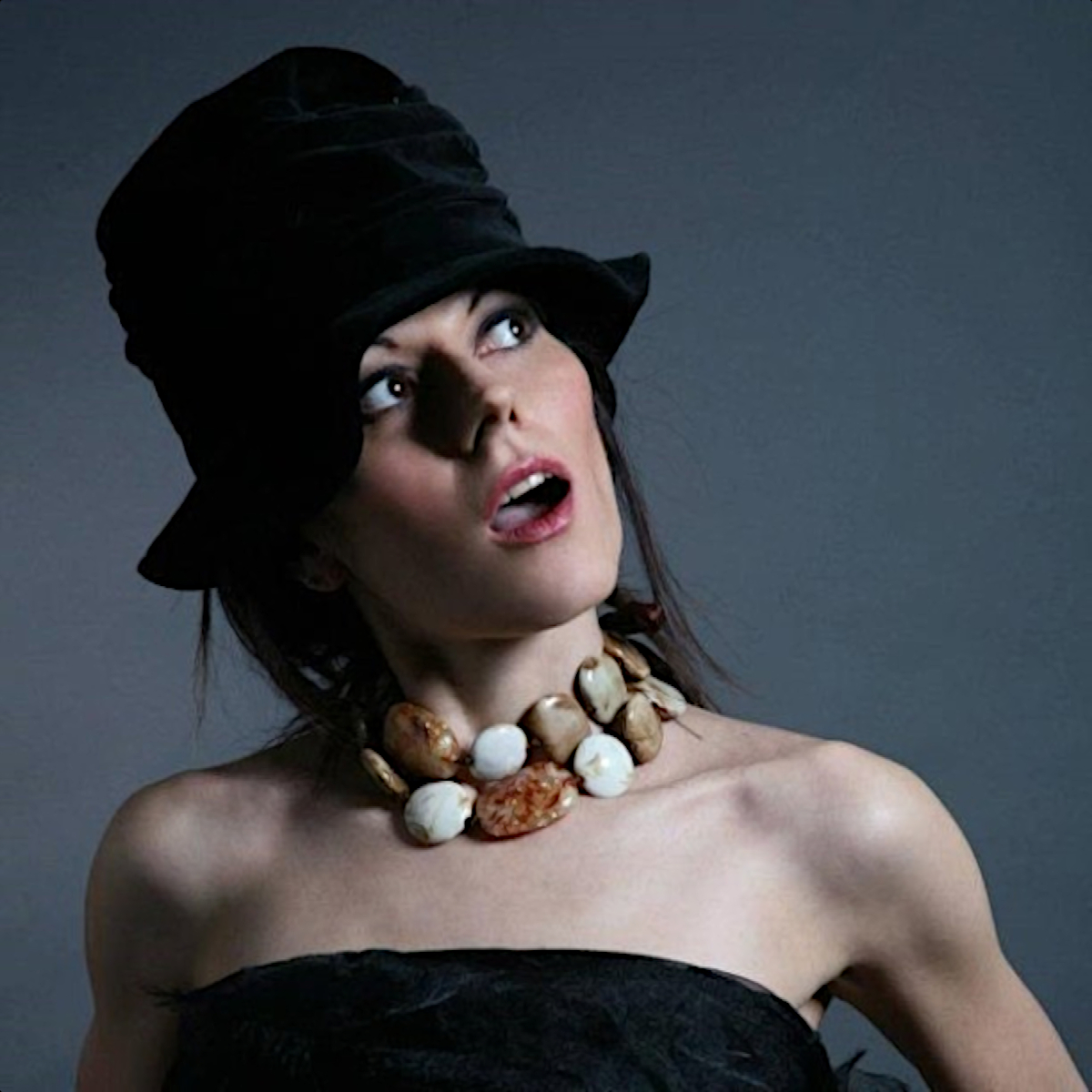 Italian DJ and producer Kika TerremotoDJ standing looking up with her mouth open wearing a hat, colour image.