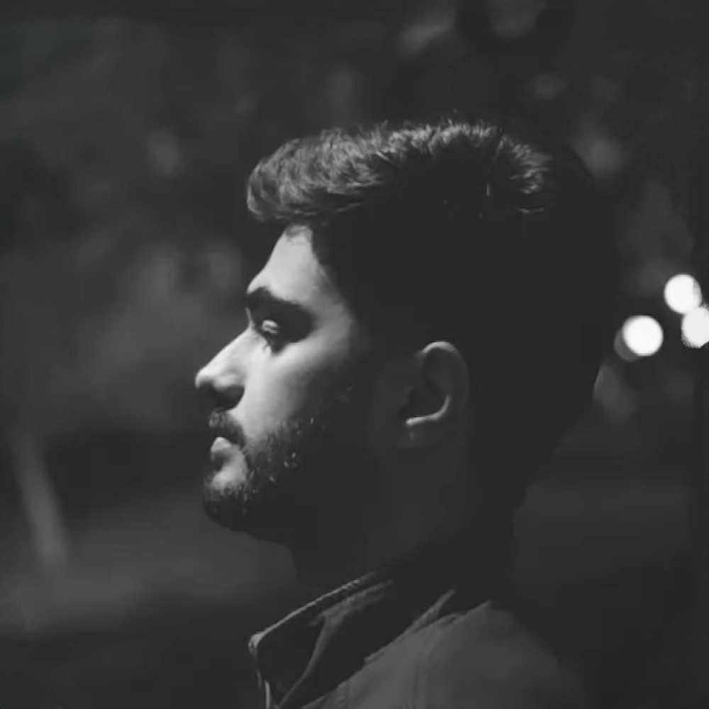 Pakistani DJ and Producer BAAKH (PK) standing in a left sided head shot, black and white image.