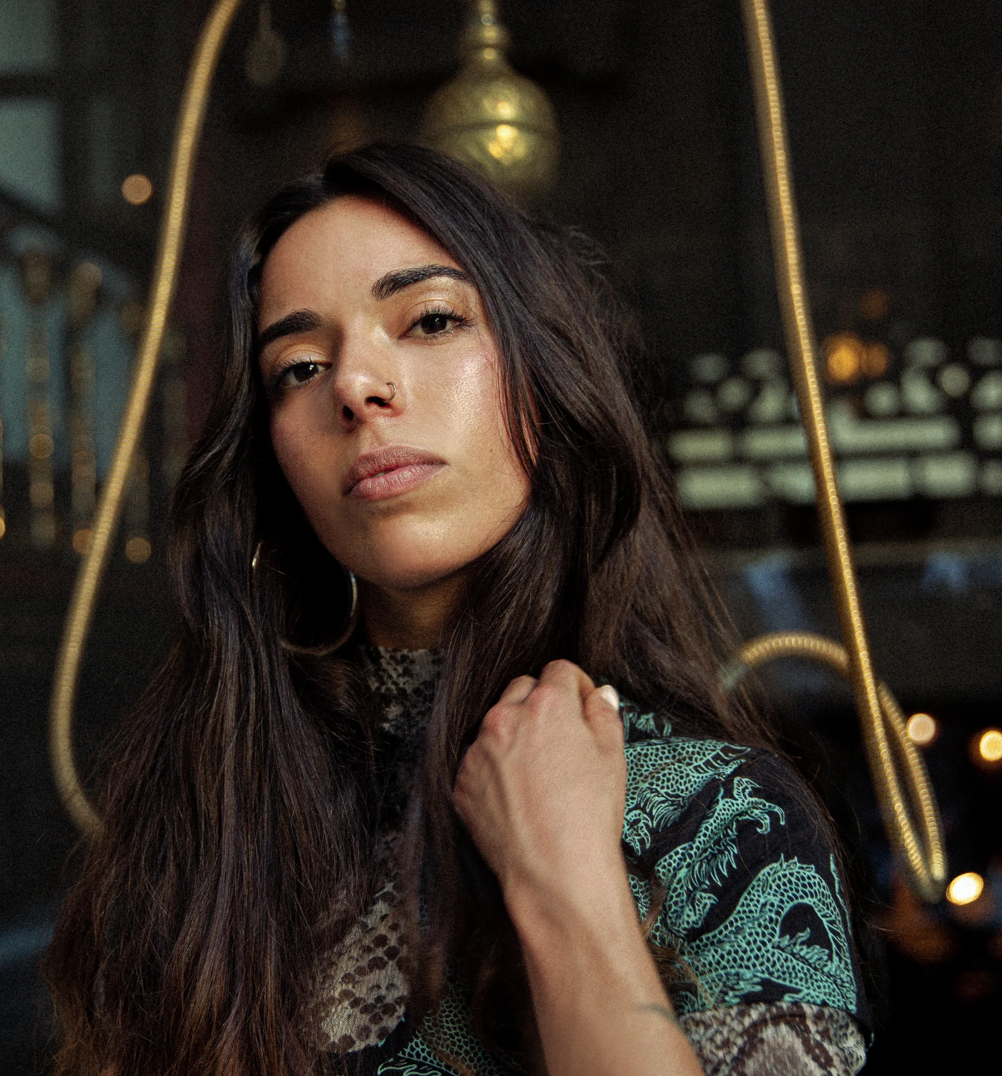 French DJ and producer Camelia looking at camera whilst holding her hair, colour image.