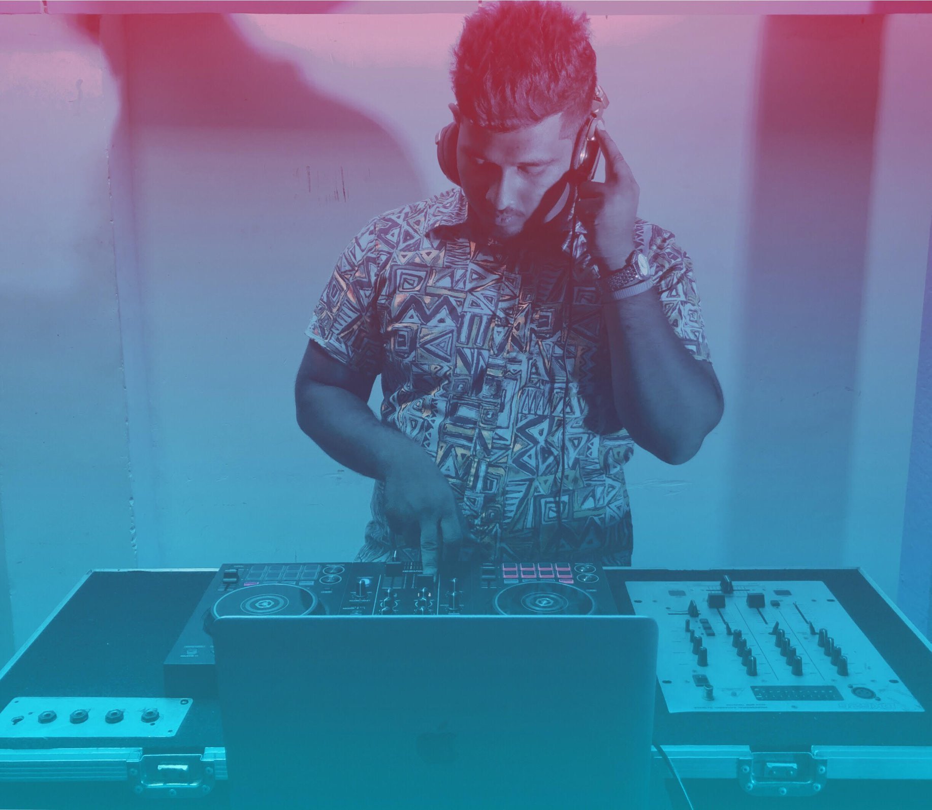 Sri Lankan guest DJ Pahan performing at event on DJ Controller with blue lighting.