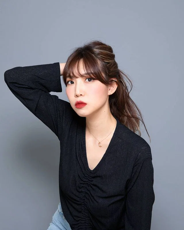 Studio portrait of South Korean DJ PLOI with one hand behind her head, representing her Funky House, Disco House and Soulful House sound.