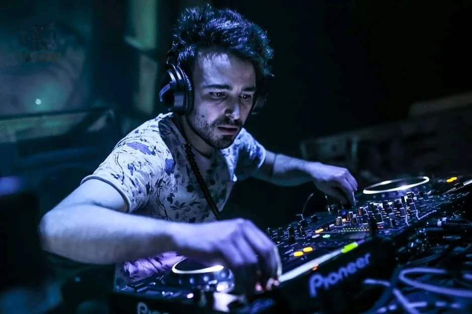Italian DJ and Producer Emison performing on Pioneer CDJs at an event, colour image.