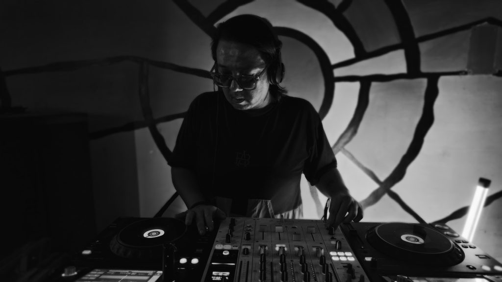French DJ Manny performing at an event in Saigon, Vietnam, black and white image.