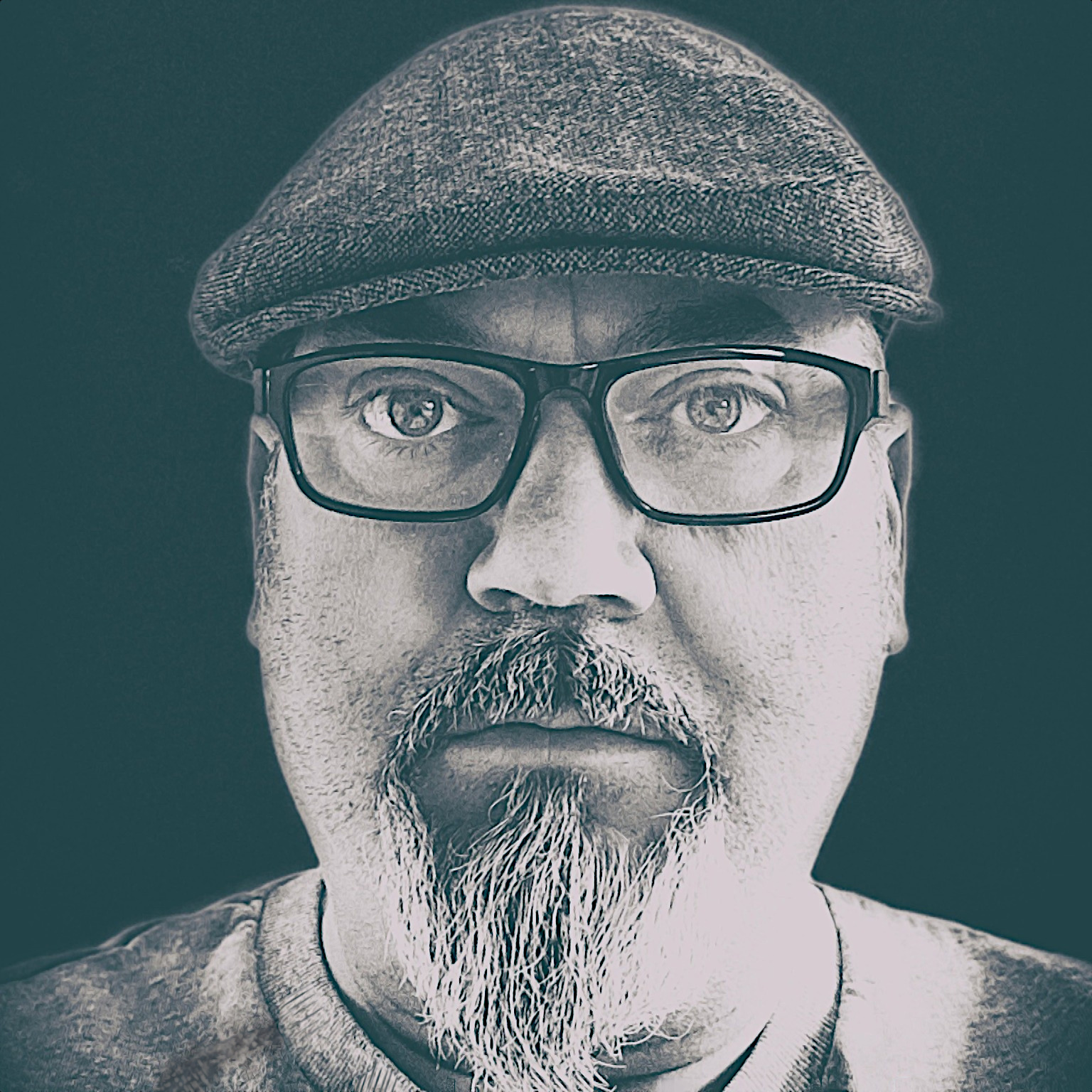 Scottish DJ and producer Allan McLoud standing looking at the camera wearing a flat cap and glasses, black and white image.