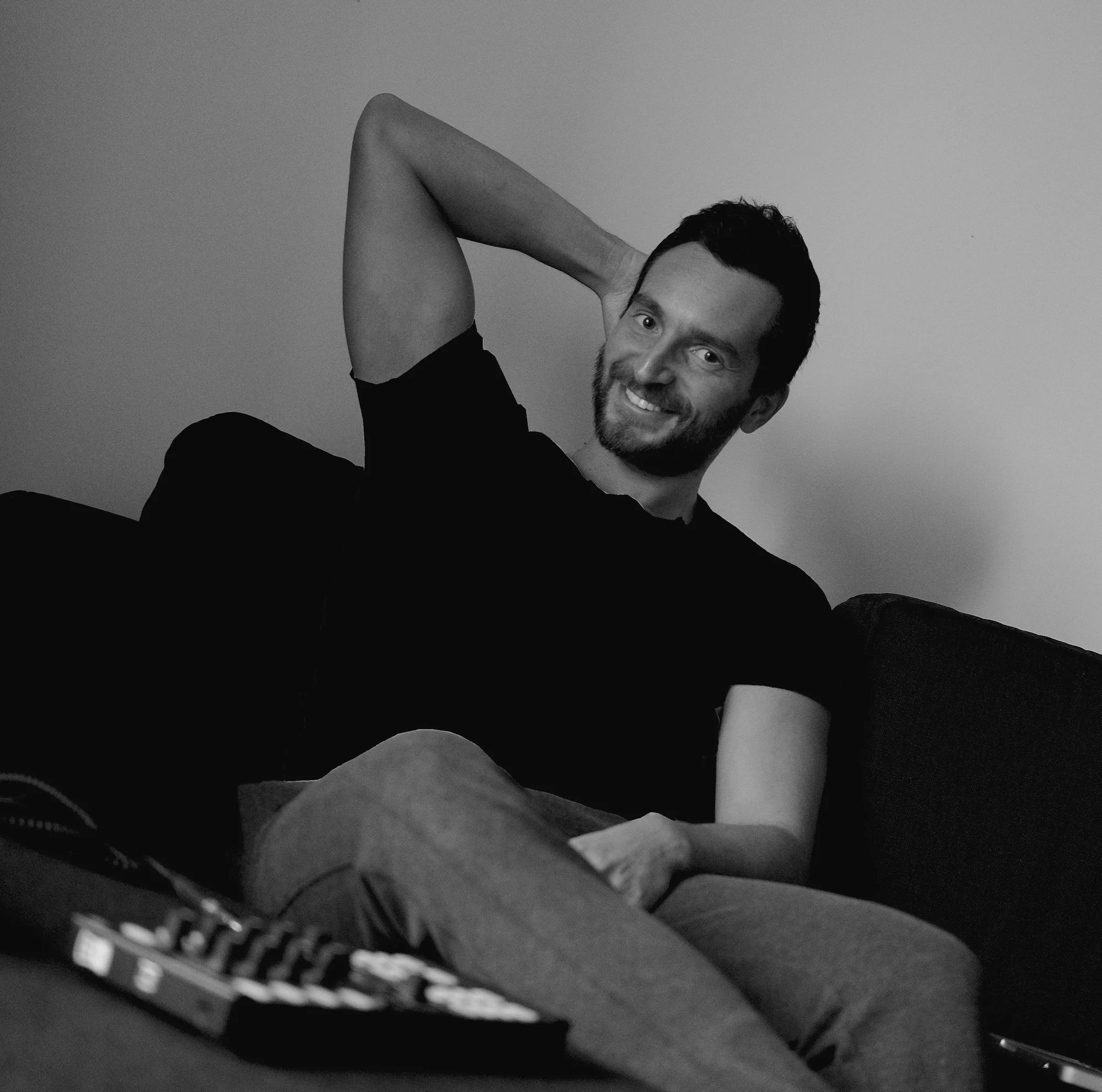 Italian DJ and producer INVE sitting in chair looking at camera, colour image.