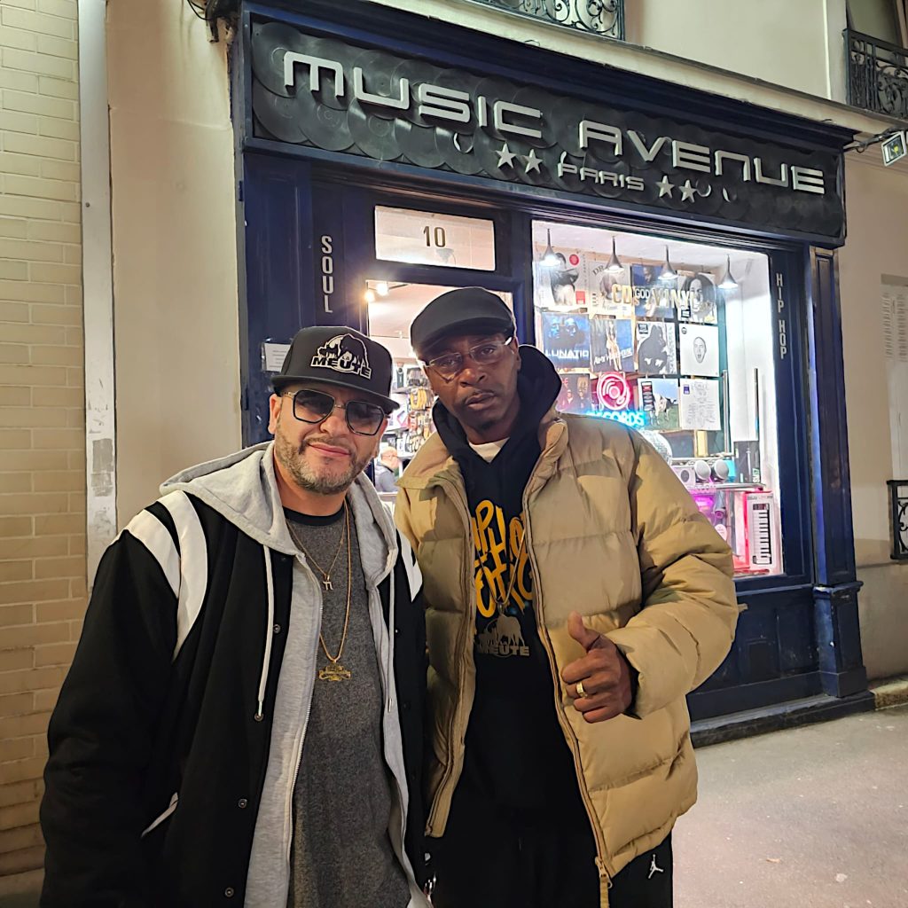 DJ Ronsha & G-Zon standimng in the street in Paris, France outside Music Avenue record store, colour image.