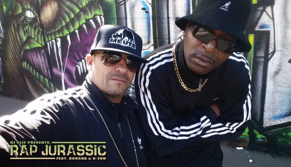 DJ Ronsha & G-Zon standing in front of a graffiti wall in Paris, France, colour image.