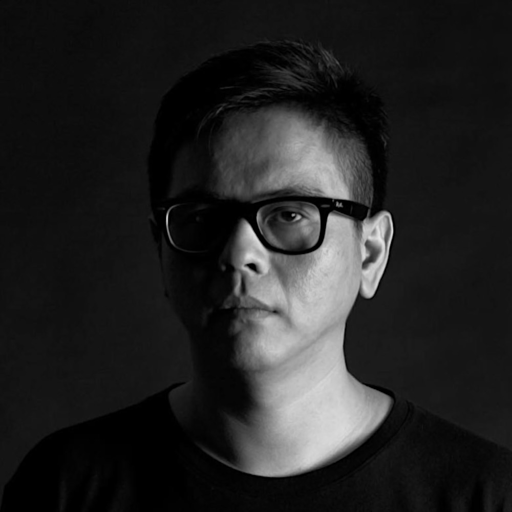 Malaysian DJ and producer Terence C in a head shot in the studio wearing glasses and looking at camera, black and white image.