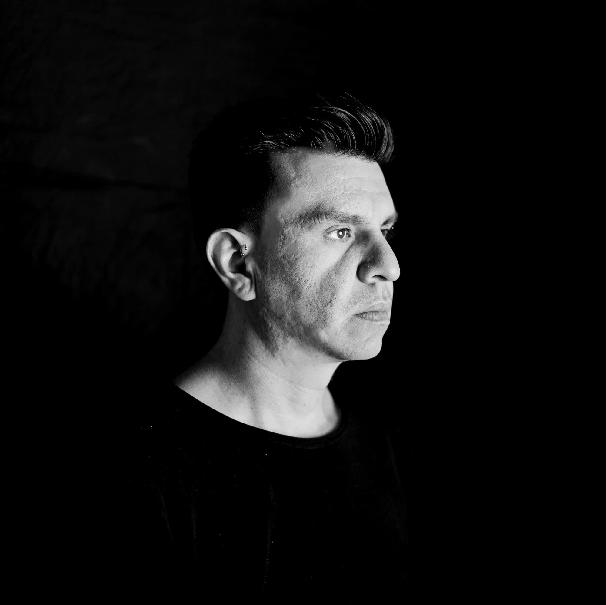 Black-and-white portrait of Ecuadorian DJ and producer Mar-k in side profile against a dark background, representing his House and Minimal sound.