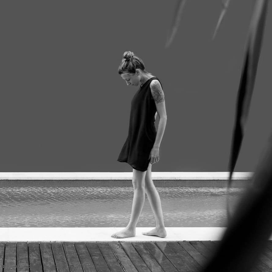 Argentinian DJ and Producer Bodai walking along swimming pool, side picture in black and white.