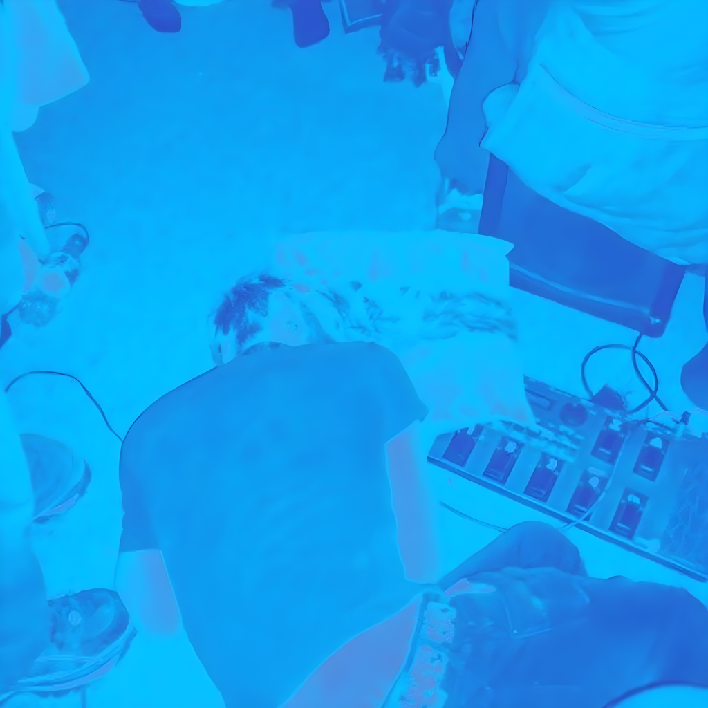 Blue-tinted promotional image for Yushka’s House Party show showing a person asleep on the floor at a house party, surrounded by people, chairs and audio equipment.