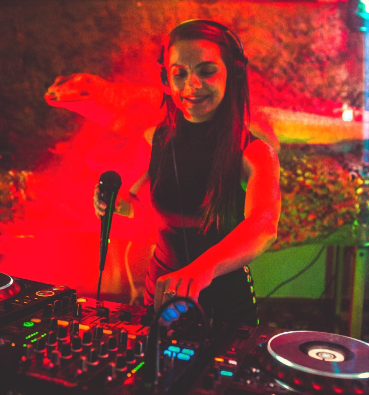 British Female DJ D-Vox performing in Ayia Napa, Cyprus on Pioneer CDJs whilst holding microphone, colour image.