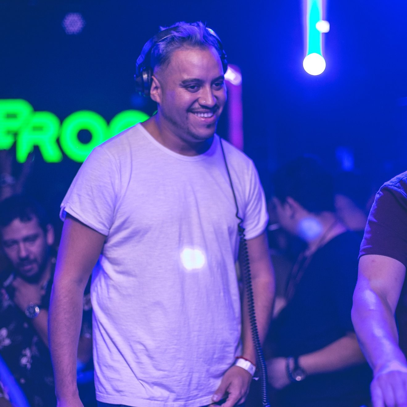 Nhà sản xuất và DJ người Chile Fabian Argomedo chuẩn bị lên sân khấu tại một sự kiện ở Chile, đang đeo tai nghe và mỉm cười, ảnh màu.