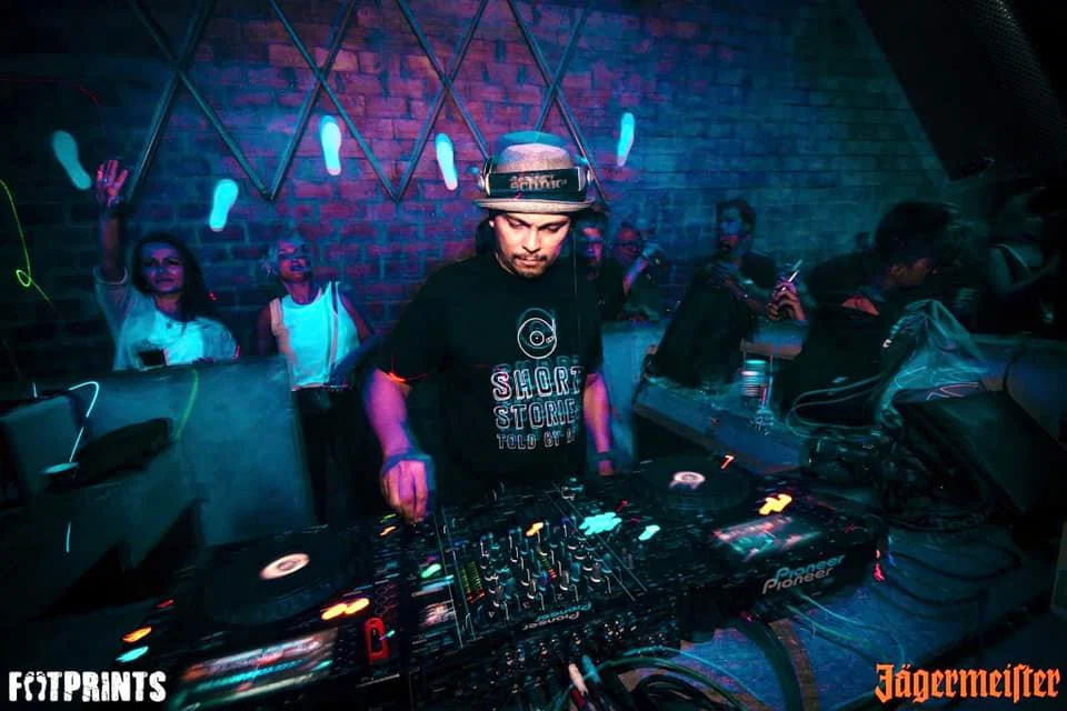 Filipino DJ and producer Herb Cabral performs behind a Pioneer DJ setup at Footprints in Manila, representing his work across House, Techno, Deep House, Afro House and Melodic House and Techno.