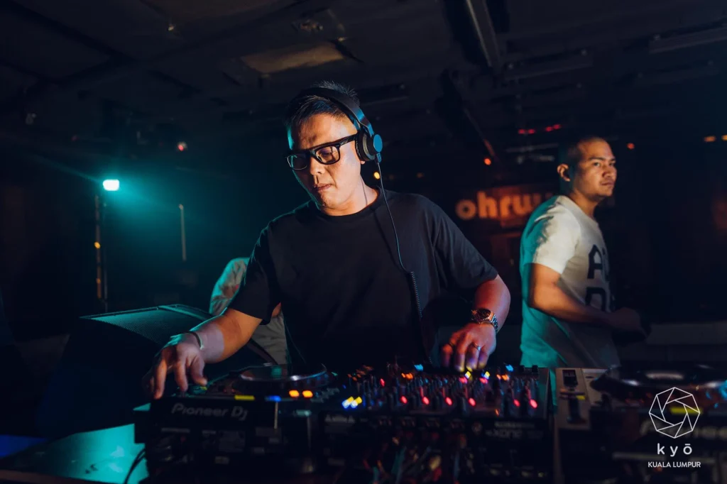 Malaysian DJ Terence C performs behind a Pioneer DJ setup at Kyo Kuala Lumpur, wearing headphones during a club set.