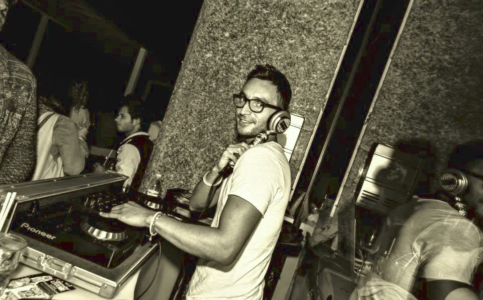 Italian DJ and producer Inve performing on pioneer controller, black and white image with beige tinge.