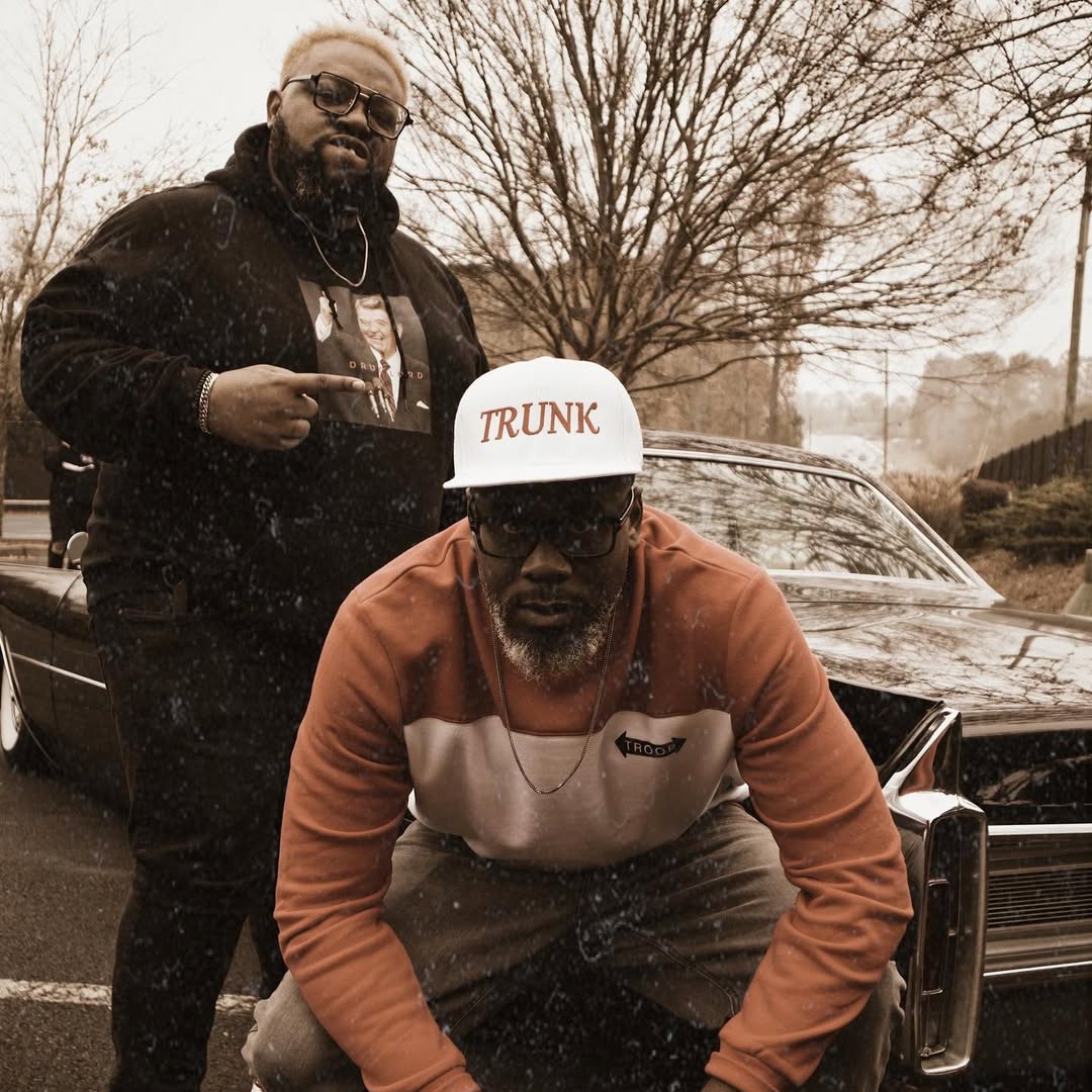 Trong hình, hai rapper sinh tại Mỹ là Big Sant và Redcoat Da Poet đang tạo dáng trước một chiếc xe hơi, trong đó Big Sant ngồi chồm hổm còn Redcoat Da Poet đứng phía sau anh ấy. Cả hai đều mặc trang phục phong cách ghetto trong một ngày tuyết rơi, và khung cảnh tràn ngập sắc màu rực rỡ cùng năng lượng dồi dào.