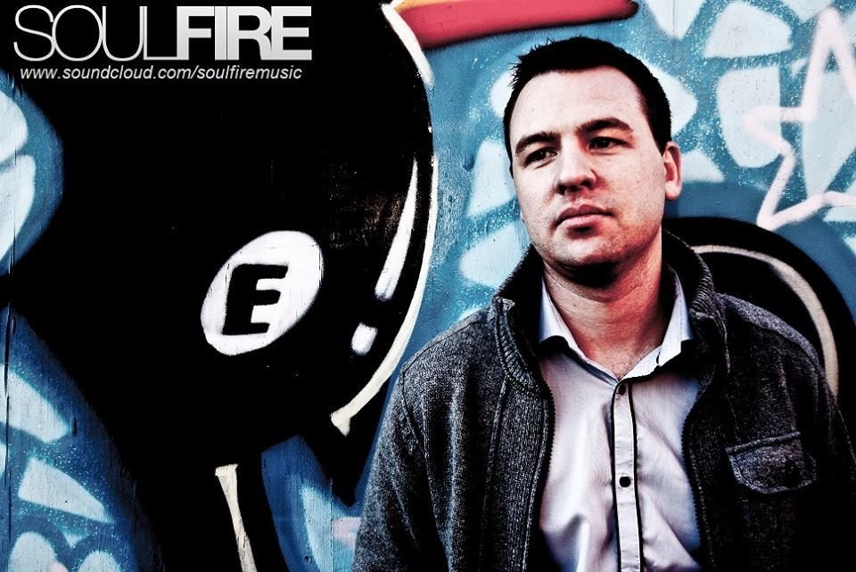 Liverpool DJ and producer Soulfire standing in front of Graffiti wall.