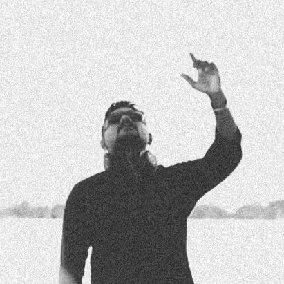 Sri Lankan DJ and producer Shanil Alox pointing up to the sky with his left hand, distorted image in black and white.