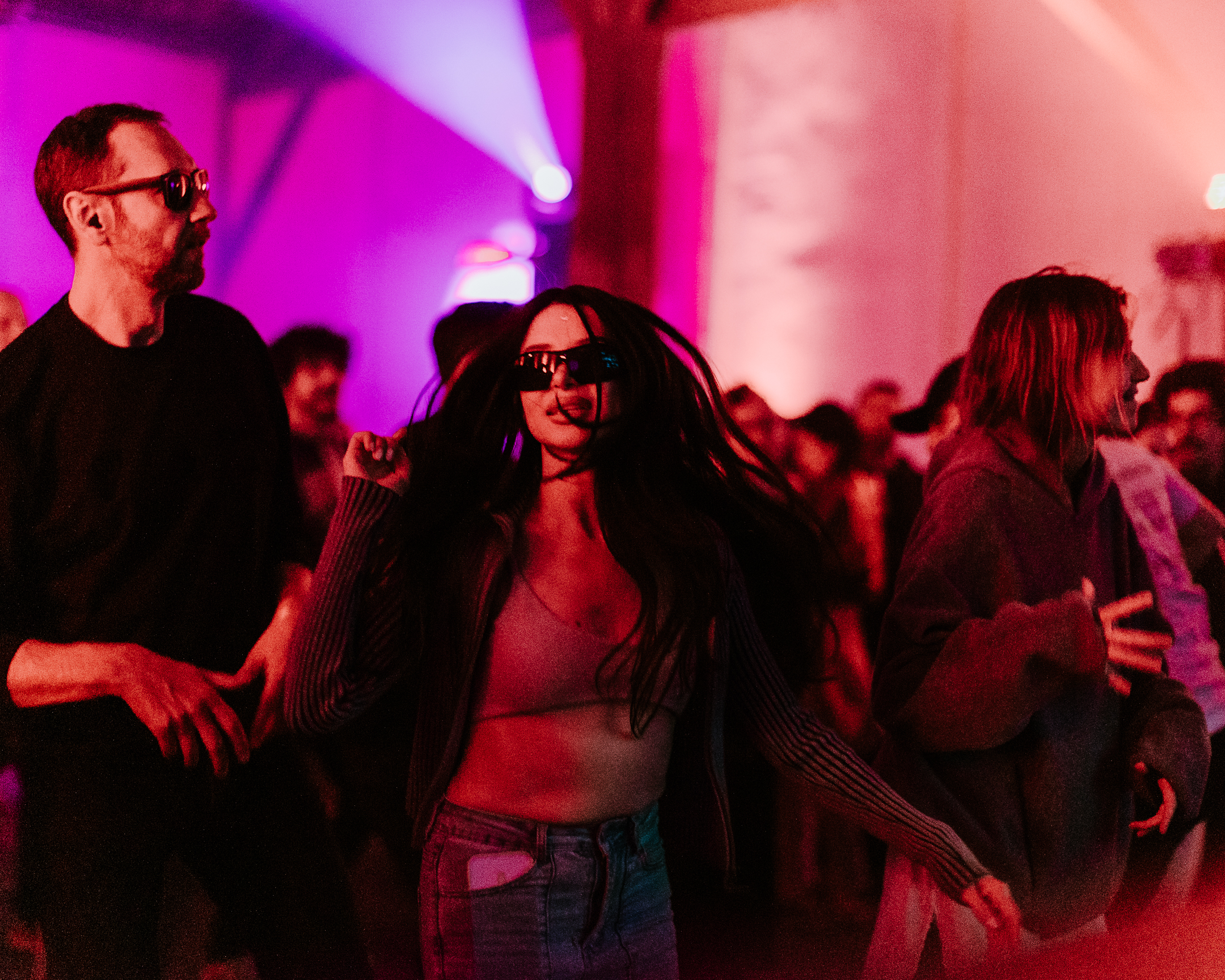 People dancing and socialising inside Parallel Society 2026 in Lisbon under pink and purple lighting during the event.