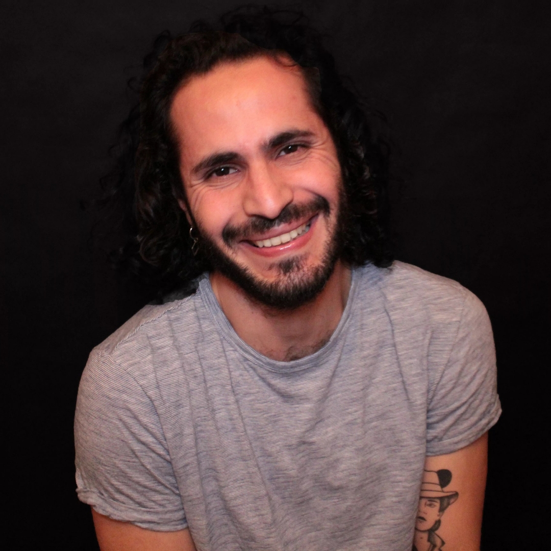 Portrait of Tunisian DJ and producer K657, also known as Khalil Abid, smiling against a black background while wearing a light grey T-shirt. Based in Montreal, his sound blends Techno, Hard Techno and Trance influences.