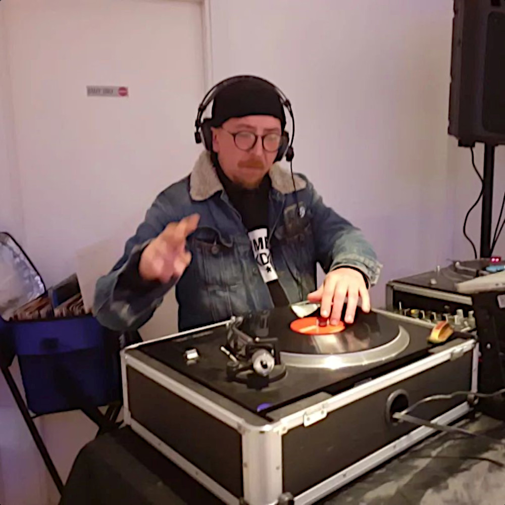 Nhà sản xuất và DJ người Ý Andrea Verona biểu diễn trên các bàn xoay Technics SL1210 tại một sự kiện, ảnh màu.