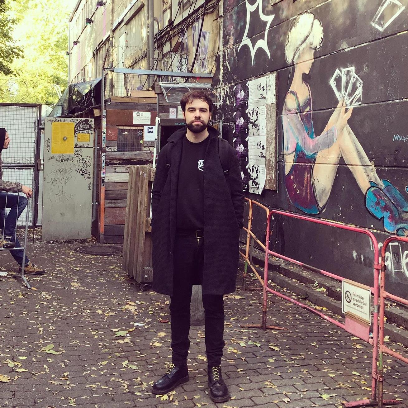 DJ và nhà sản xuất người Scotland Paulitical a.k.a Scottish Power đứng cạnh bức tường graffiti tại Glasgow, ảnh màu.