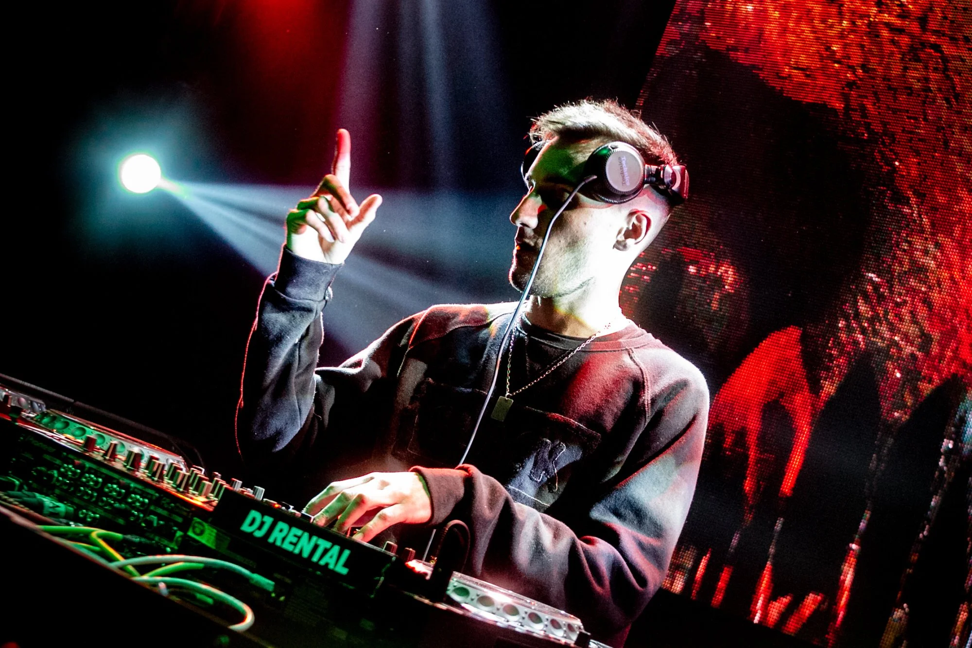 Argentinian DJ and producer JFR (Juan Franco Rivero) performing as a DJ on Pioneer CDJs with one finger in air, colour image.