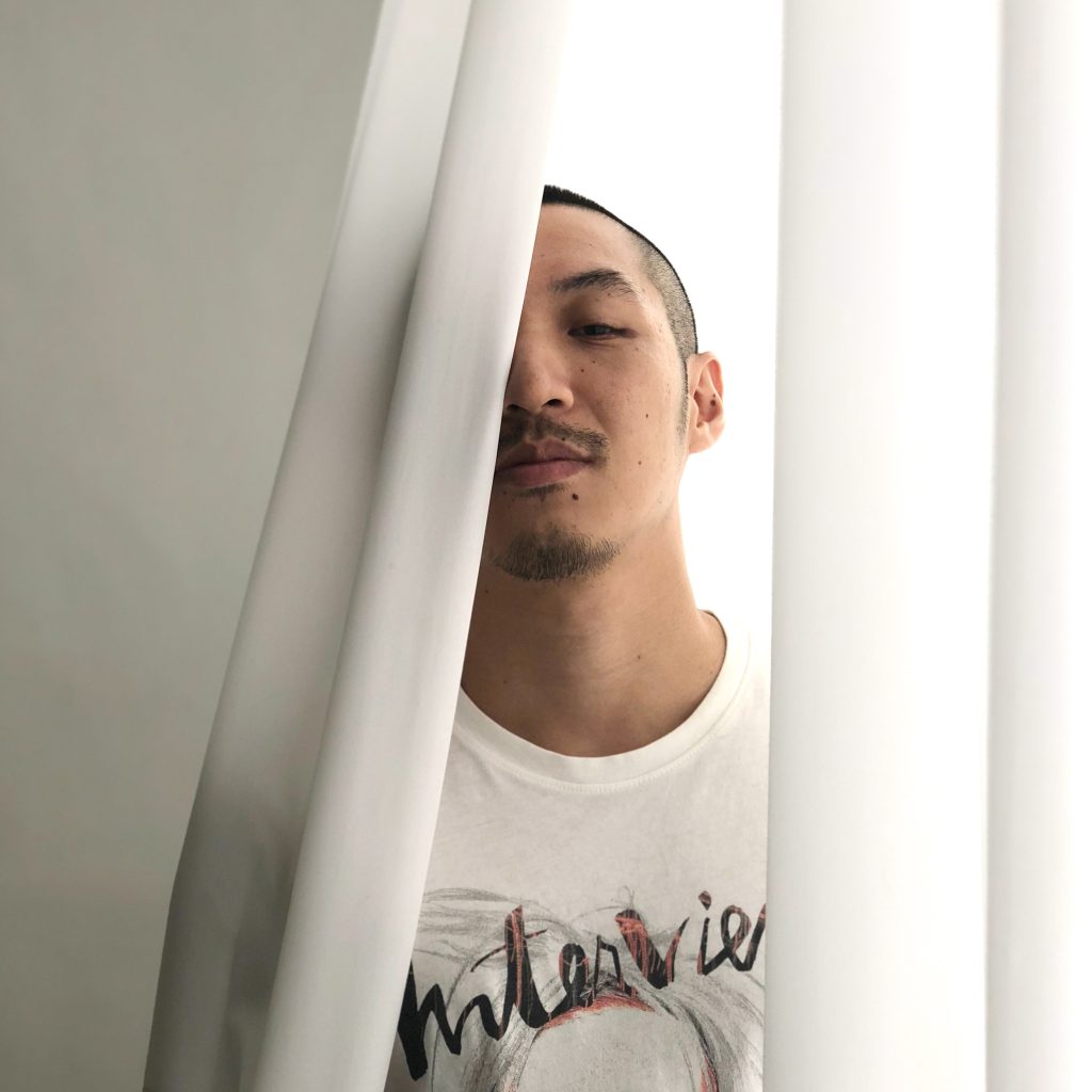Taiwanese DJ and producer Jesse Chen behind a Curtain, colour image.