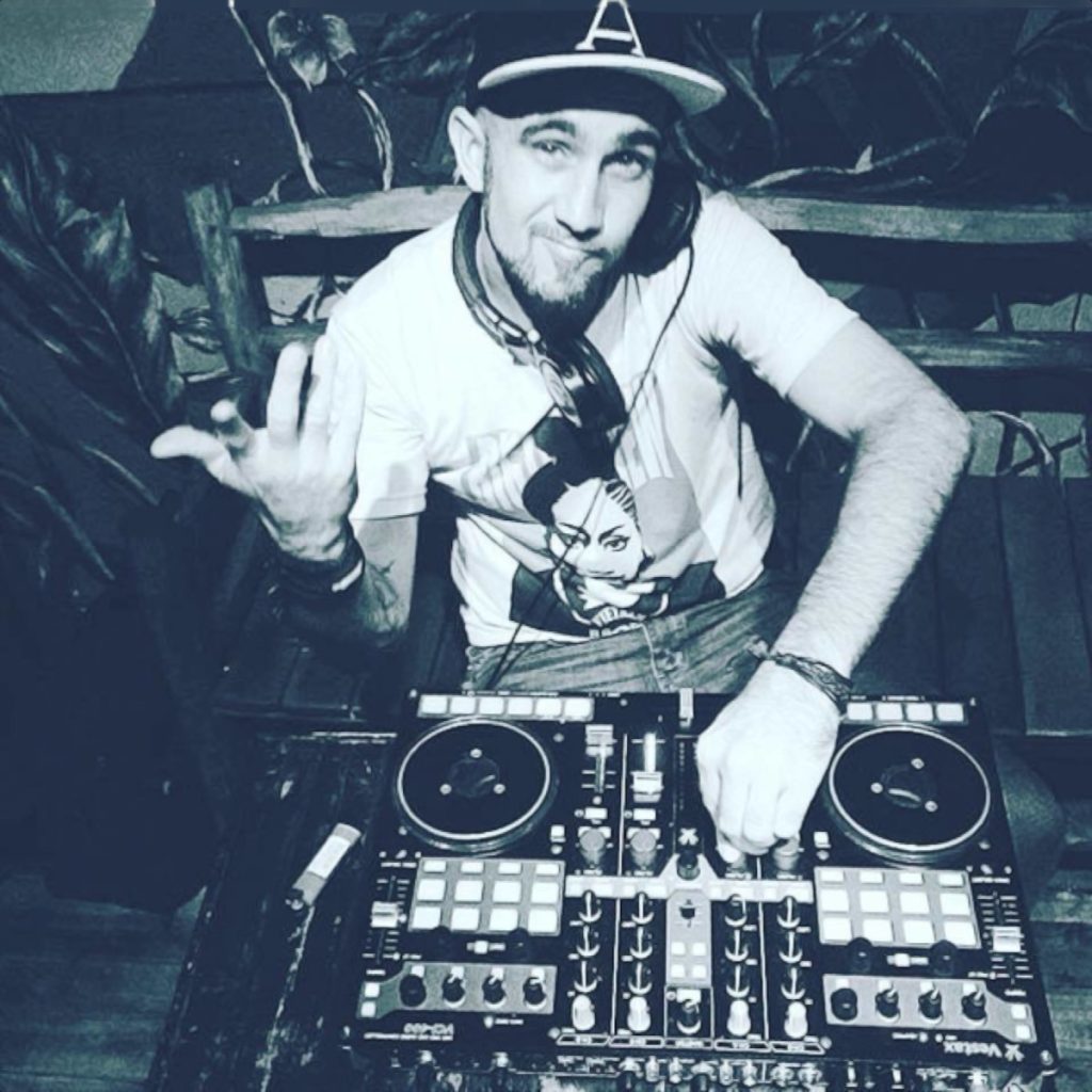 French DJ G Nomad performing at a venue as a DJ on Vestax Controller, picture is blue tinted.
