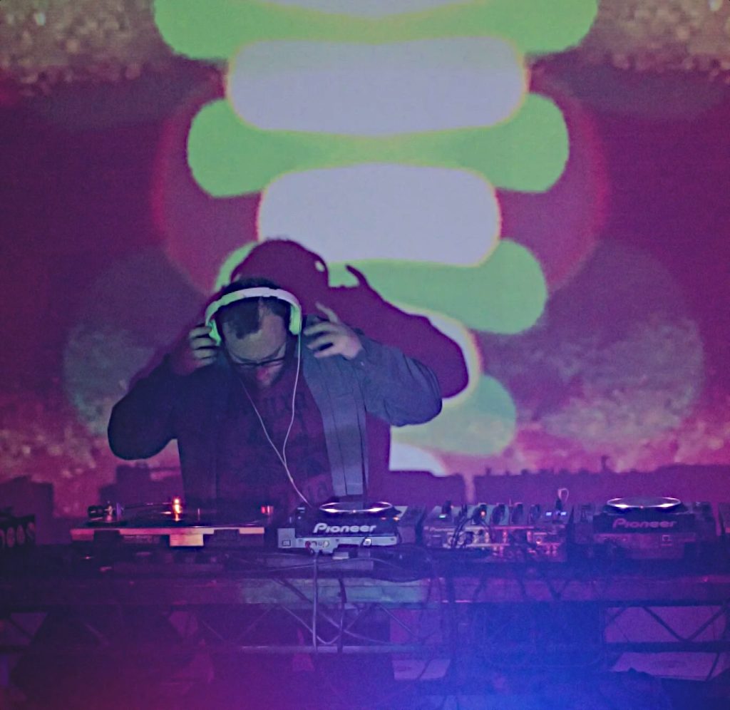 British DJ Tam Yeung performing at an event as a DJ, colour image