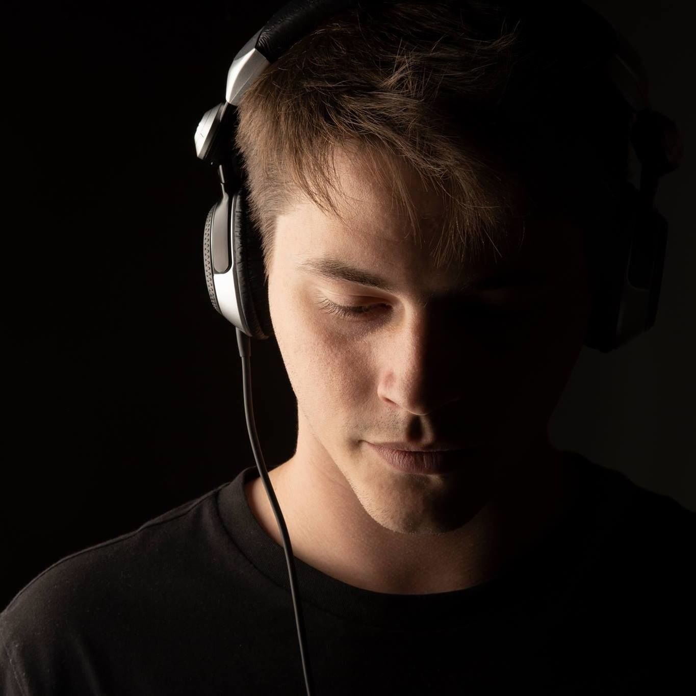 Argentinian DJ and producer Nico Szabo in a profile portrait wearing headphones, colour image.