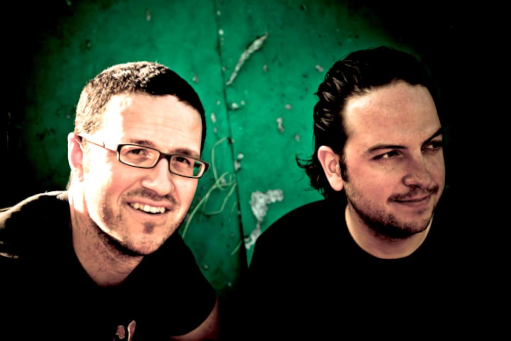 DJ and production duo Dominique Heyninck and Dimitri Chantzis (Mitrinique) together with a green wall behind them, colour image.