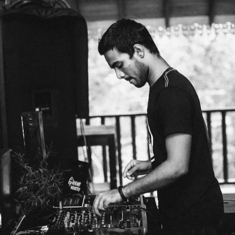 Sri Lankan DJ Darius performing at an event using Pioneer DJ equipment, side picture in black and white.